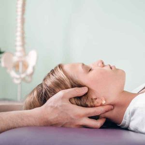 Une femme reçoit un massage du cou par un chiropraticien.