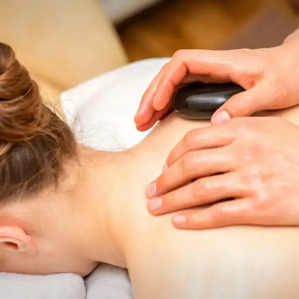 Une femme recevant un massage aux pierres chaudes.